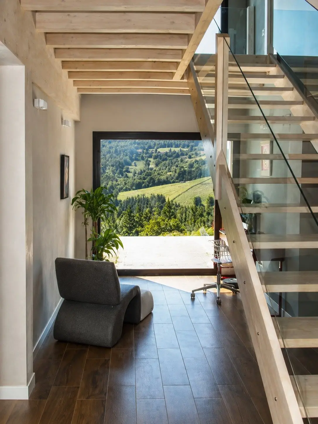 Escalera de madera y vidrio junto al ventanal con vistas Escalera de madera y vidrio junto al ventanal con vistas